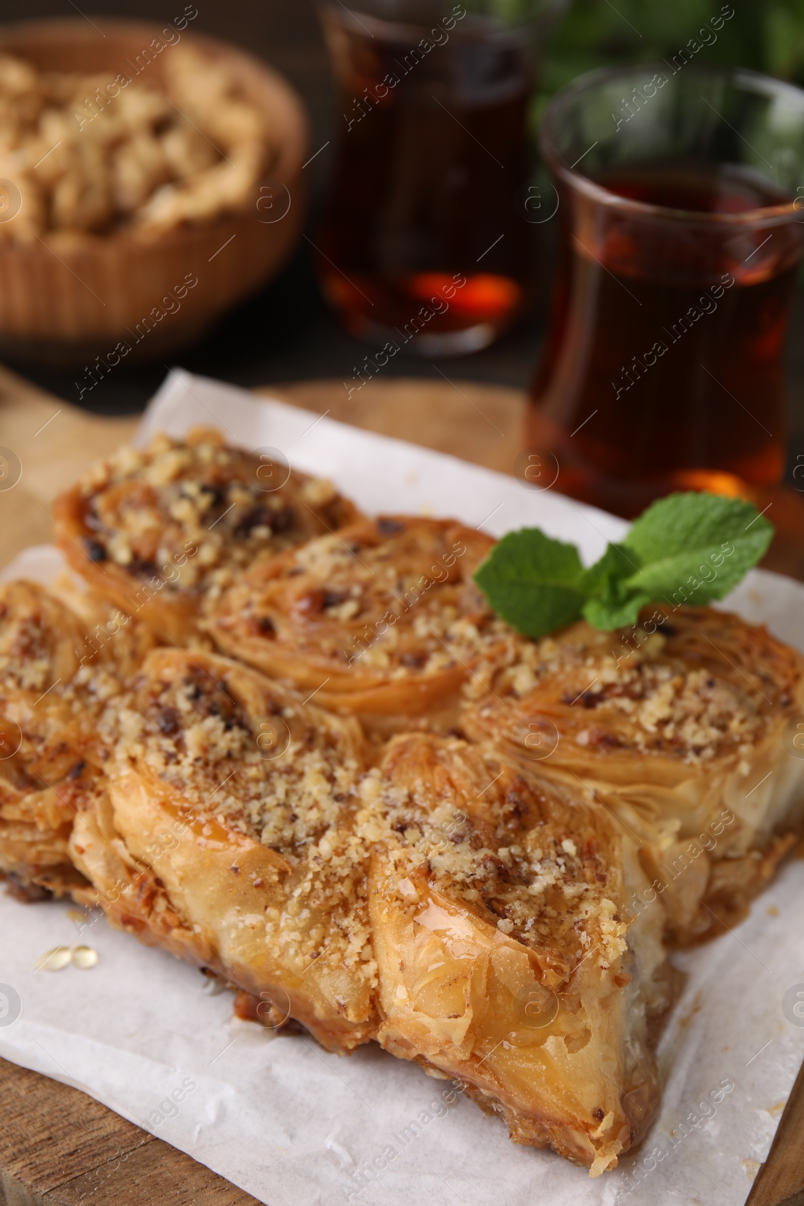 Photo of Eastern sweets. Pieces of tasty baklava and tea on table, closeup