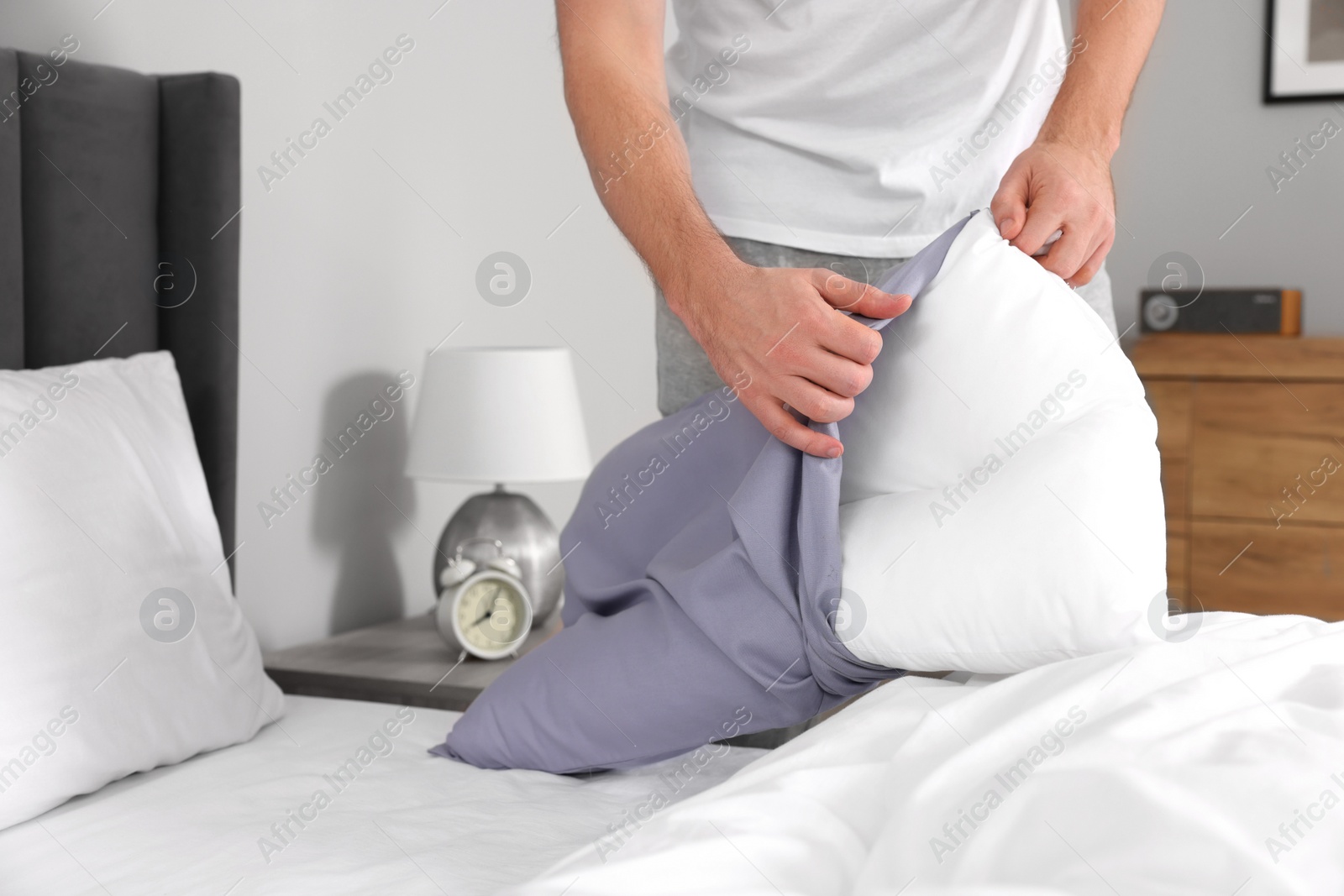 Photo of Man changing pillowcase at home, closeup. Domestic chores