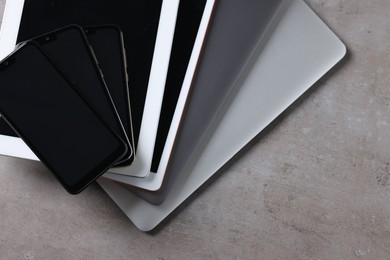 Photo of Many different modern gadgets on grey table, closeup