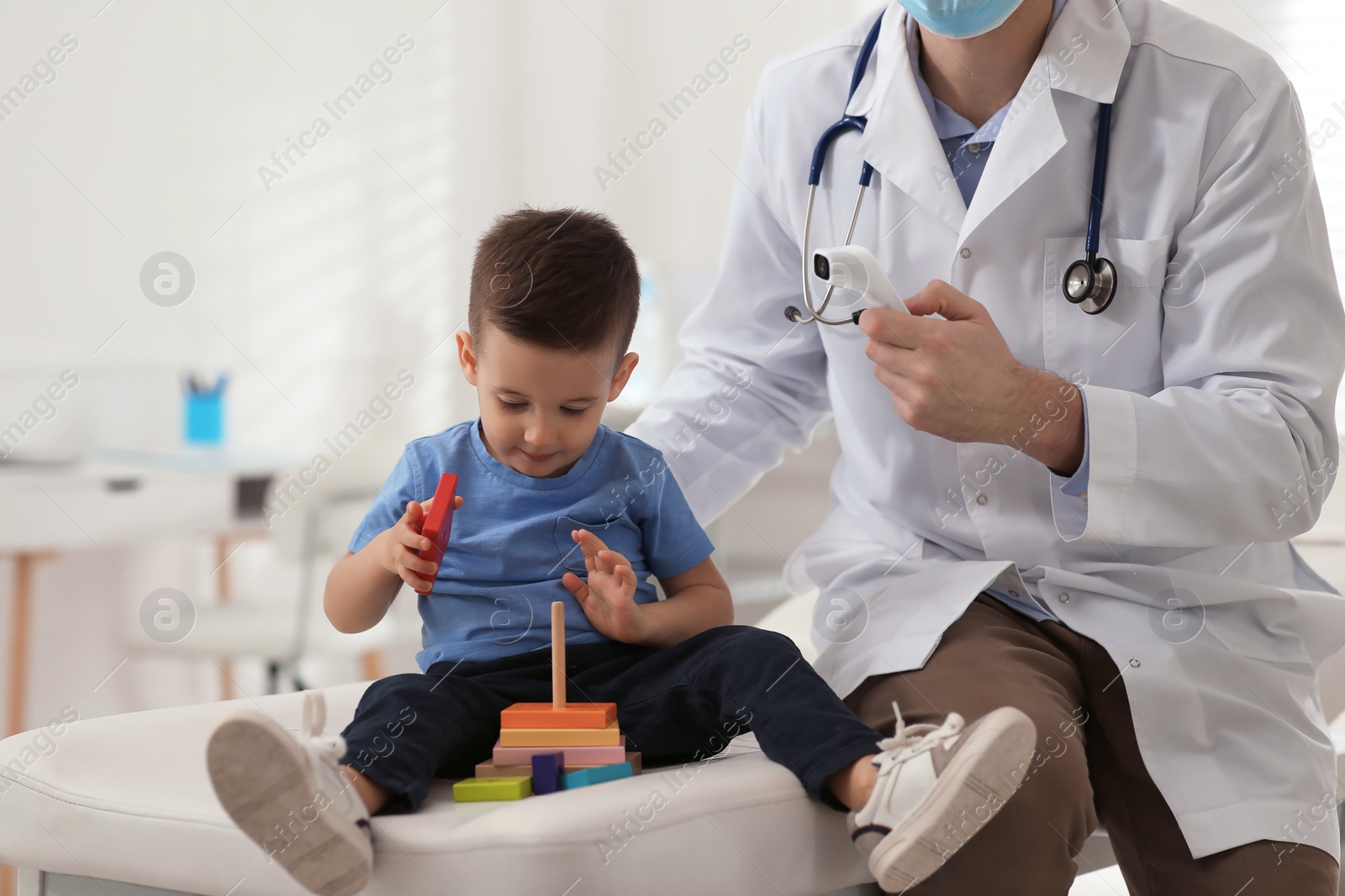 Photo of Pediatrician checking little boy's temperature at hospital