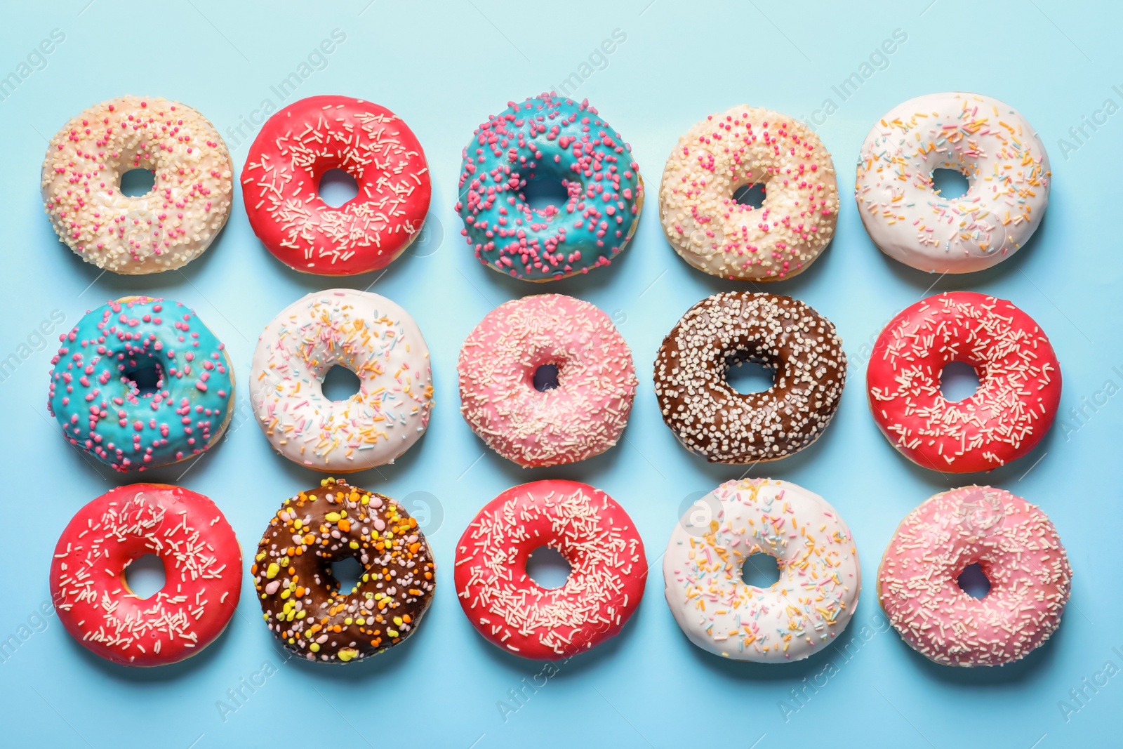 Photo of Delicious glazed doughnuts on color background, top view