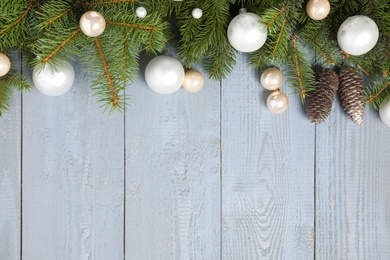 Fir branches with Christmas decoration on grey wooden background, flat lay. Space for text