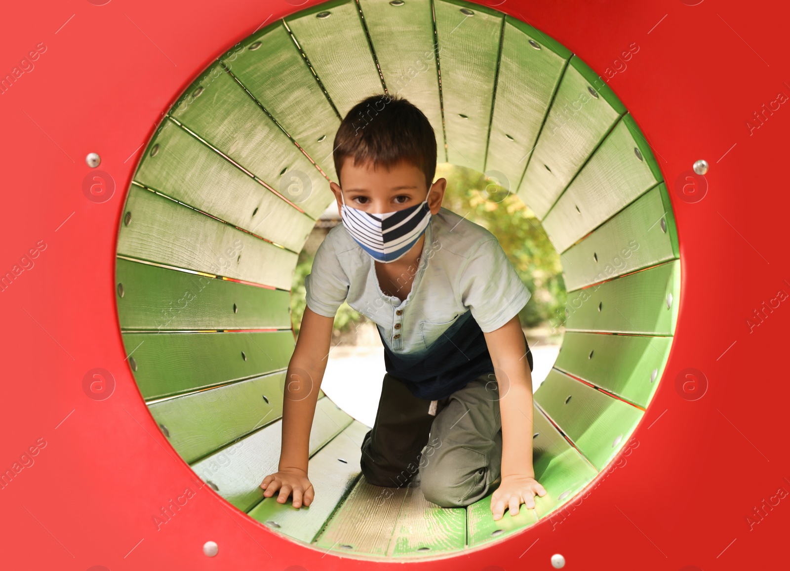 Photo of Little boy with medical face mask on playground during covid-19 quarantine