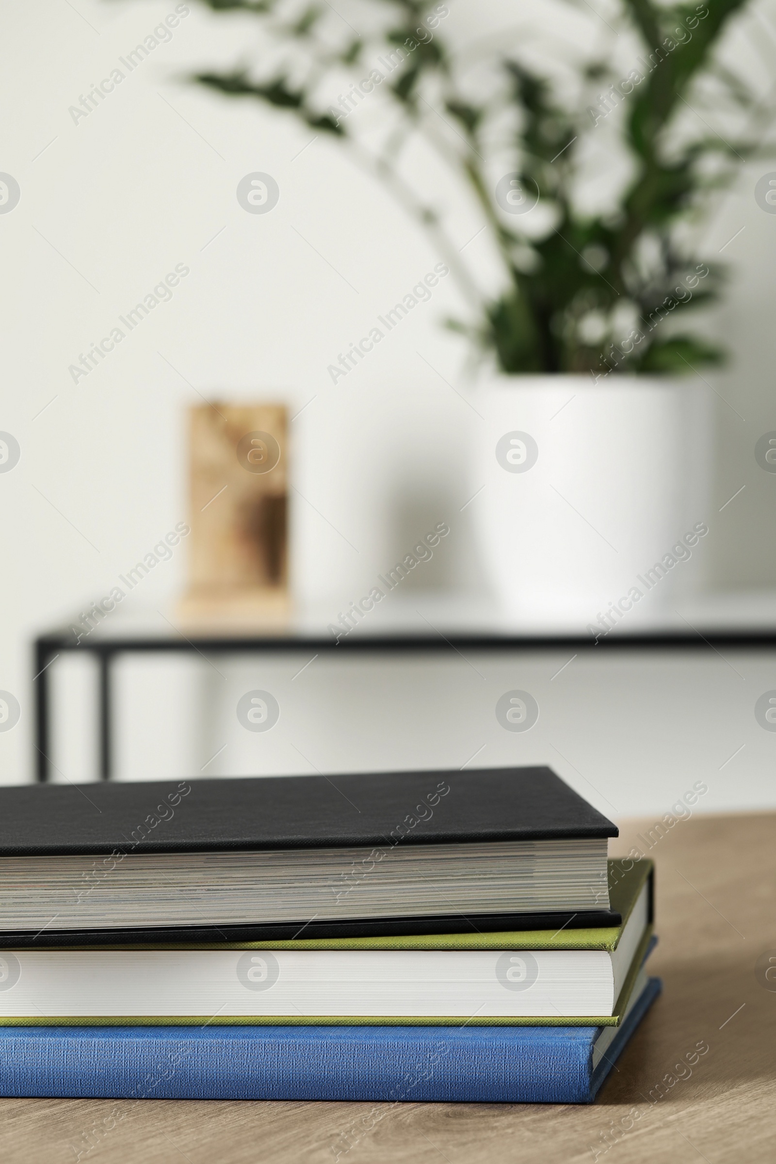 Photo of Many different books stacked on wooden table indoors