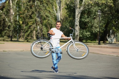 Handsome young hipster man with bicycle outdoors