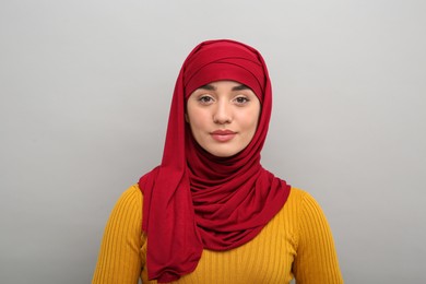 Muslim woman in hijab on light gray background