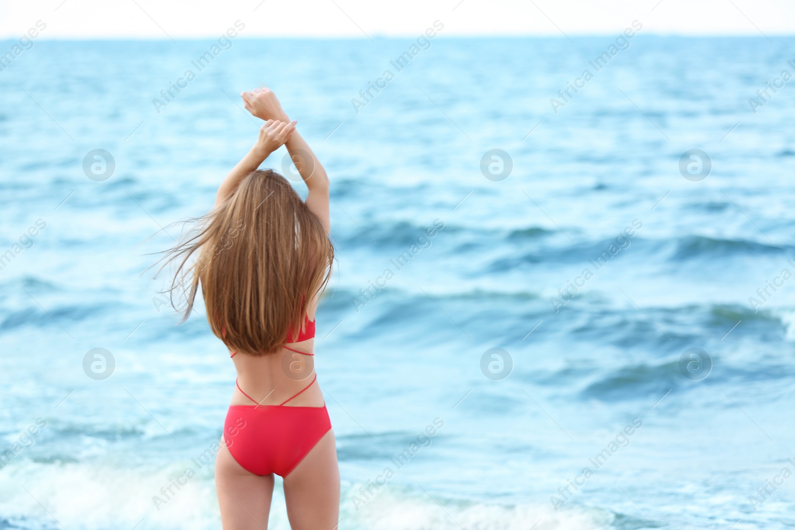 Photo of Attractive young woman in beautiful one-piece swimsuit on beach