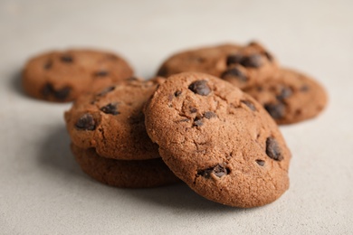 Tasty chocolate chip cookies on light background