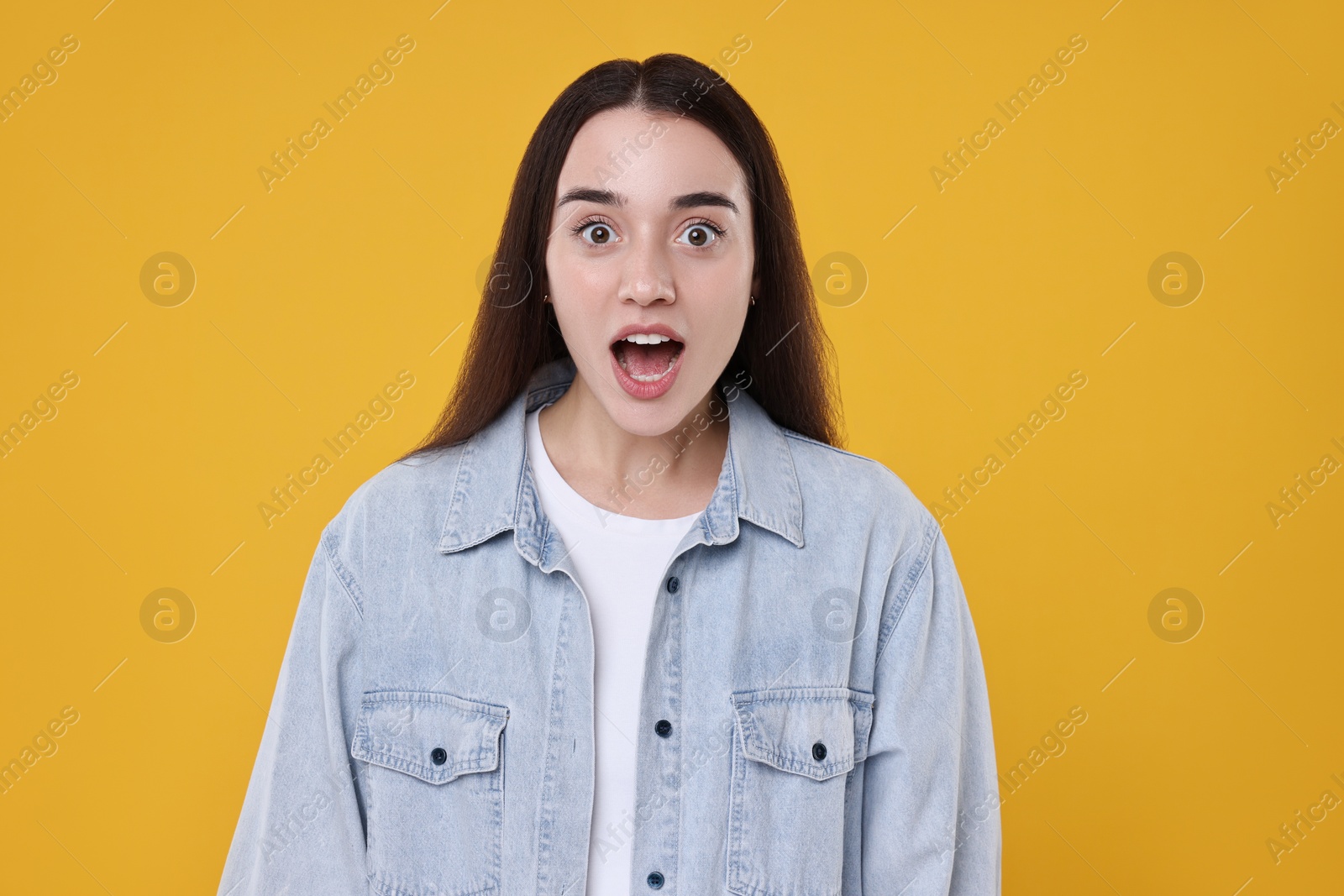 Photo of Portrait of surprised woman on orange background