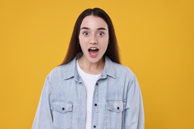 Photo of Portrait of surprised woman on orange background