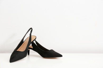 Pair of female shoes on table against white background