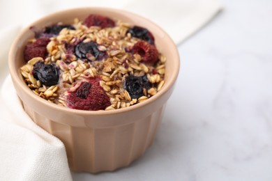 Tasty baked oatmeal with berries on white table, closeup. Space for text