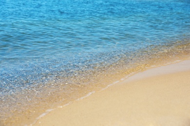 Photo of View of sea water and beach sand on sunny day