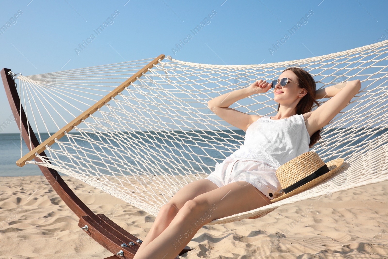 Photo of Young woman relaxing in hammock on beach