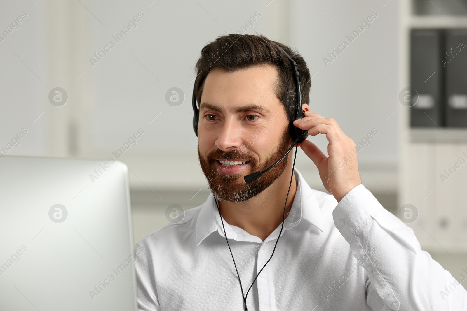 Photo of Hotline operator with headset working in office