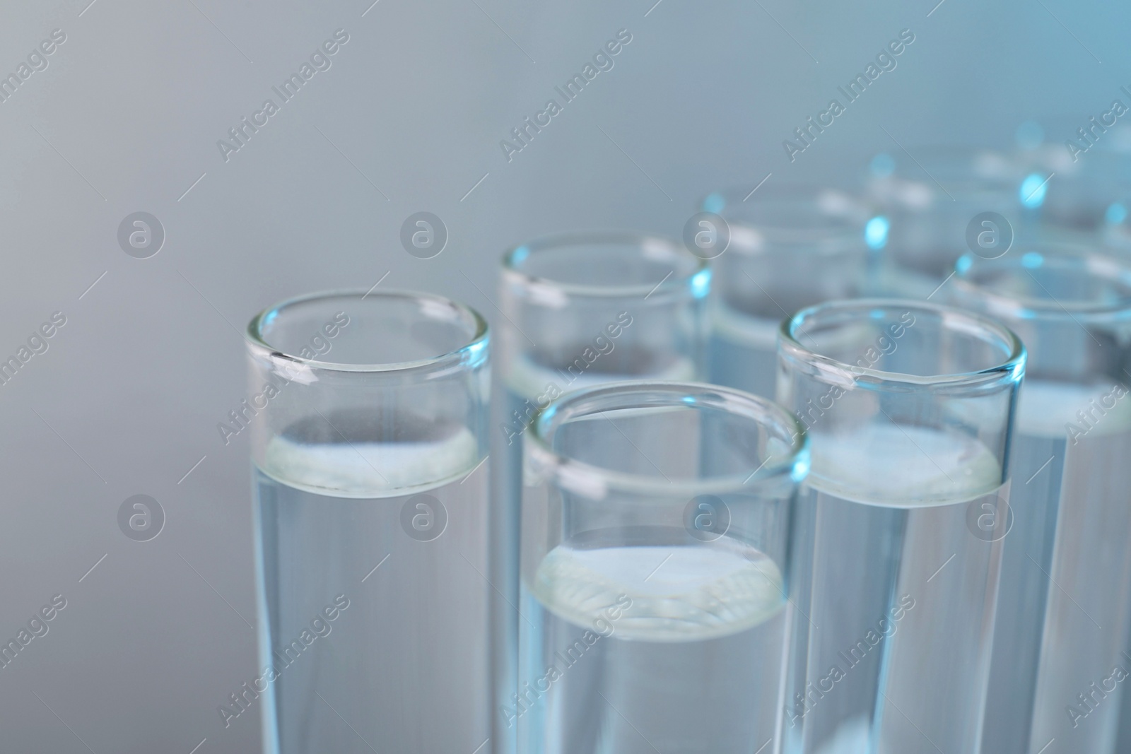 Photo of Laboratory analysis. Test tubes with liquid samples on color background, closeup