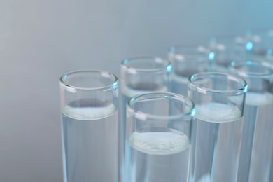 Photo of Laboratory analysis. Test tubes with liquid samples on color background, closeup