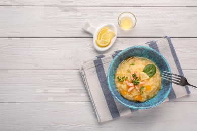 Photo of Bowl with tasty shrimps and grits on table, top view