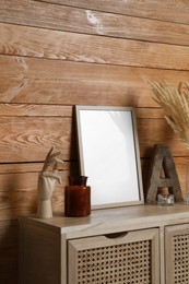 Photo of Empty frame with other decor on table near wooden wall. Mockup for design