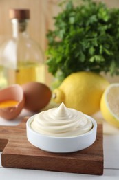 Photo of Fresh mayonnaise sauce in bowl on white wooden table