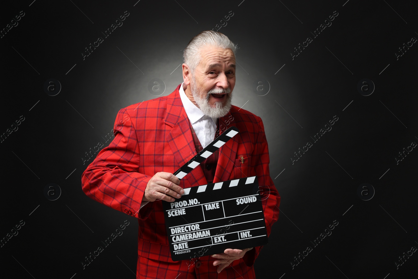 Photo of Senior actor with clapperboard on black background. Film industry