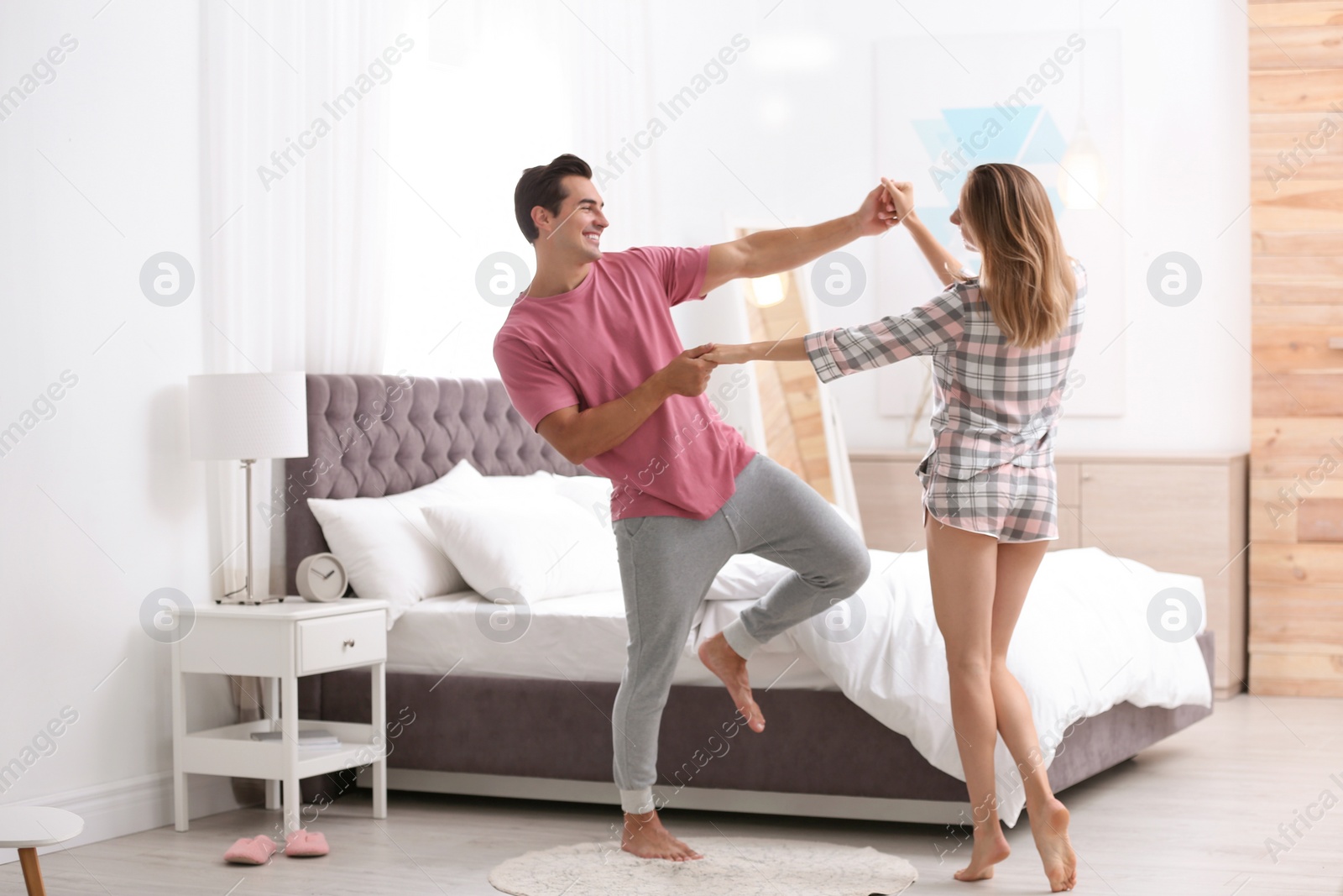 Photo of Beautiful young couple dancing in bedroom at home