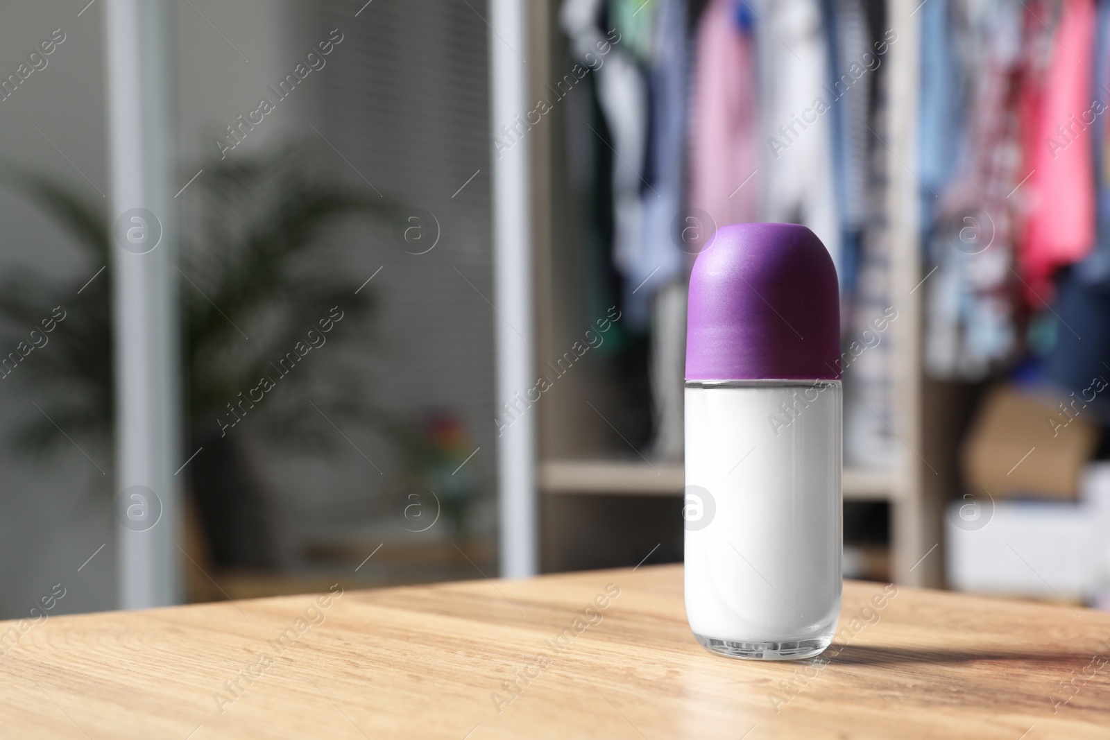 Photo of Natural female roll-on deodorant on wooden table indoors. Space for text