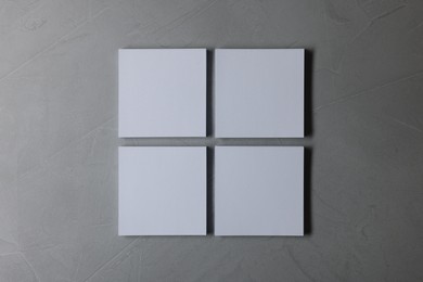 Photo of Blank paper sheets on grey textured background, top view. Mockup for design