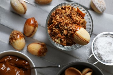 Delicious walnut shaped cookies with condensed milk on grey table, flat lay