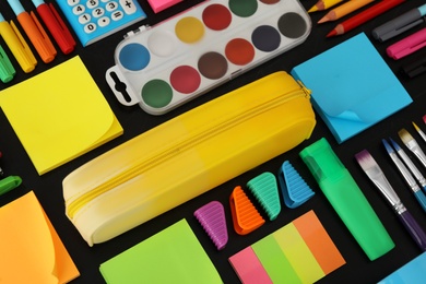 Photo of Different stationery on blackboard, closeup. Back to school