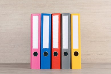 Photo of Bright hardcover office folders on white wooden table