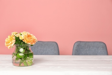 Photo of Vase with blooming flowers on table indoors