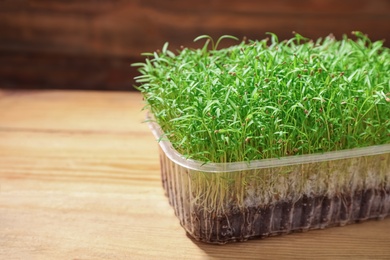 Fresh organic microgreen on wooden table, closeup. Space for text