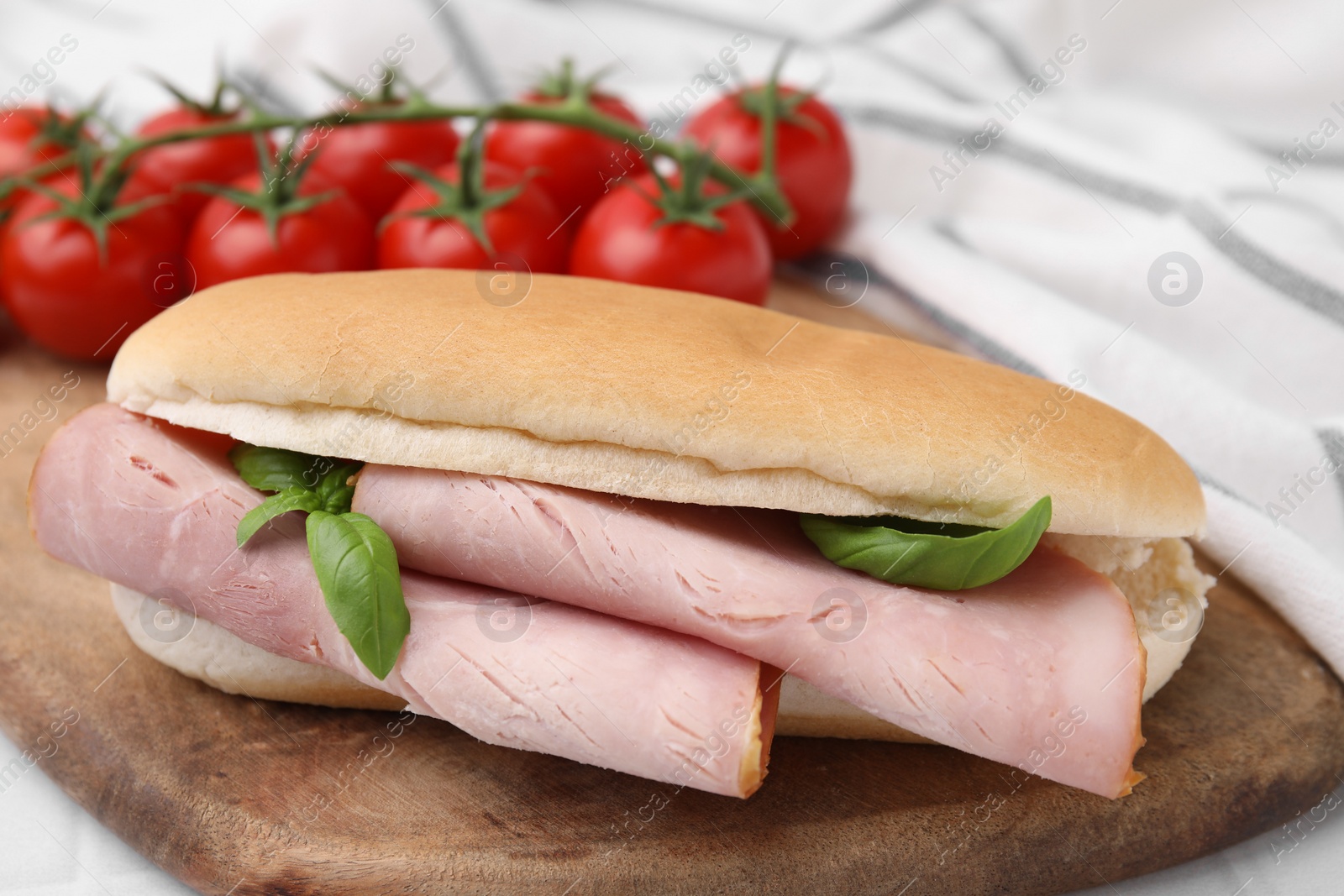 Photo of Delicious sandwich with ham and basil on table, closeup