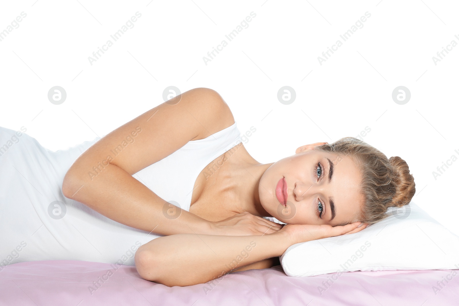 Photo of Beautiful woman lying with orthopedic pillow on bed against white background