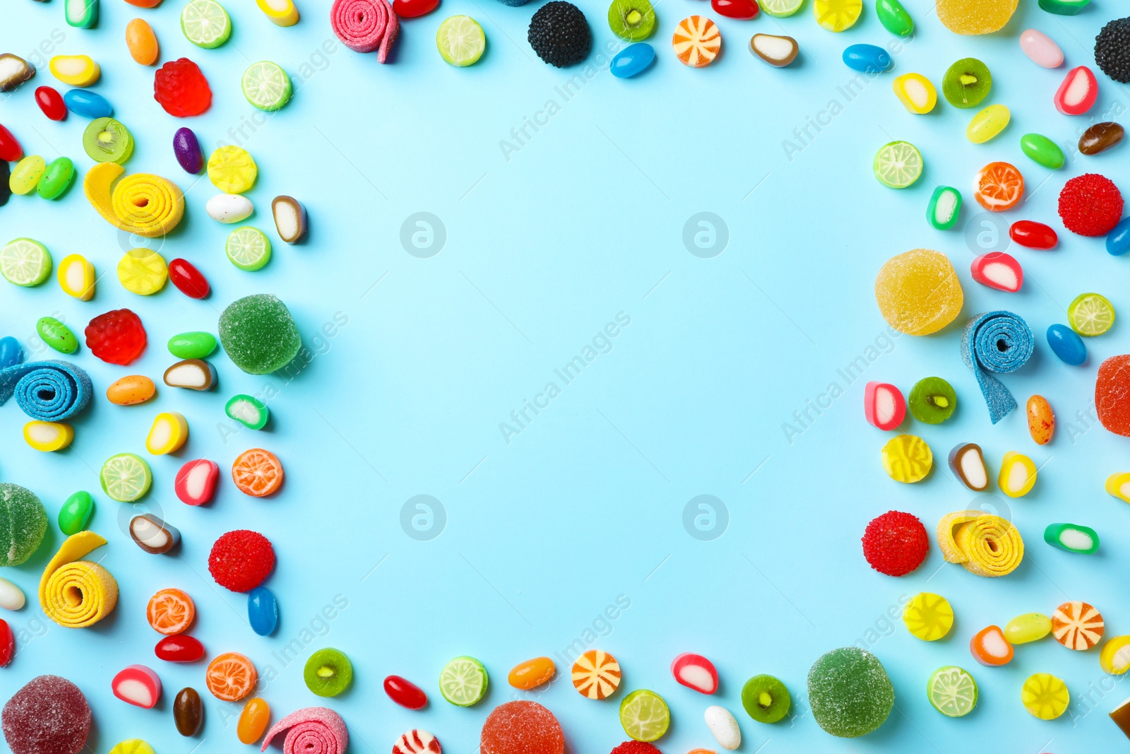 Photo of Flat lay composition with delicious colorful candies and space for text on color background