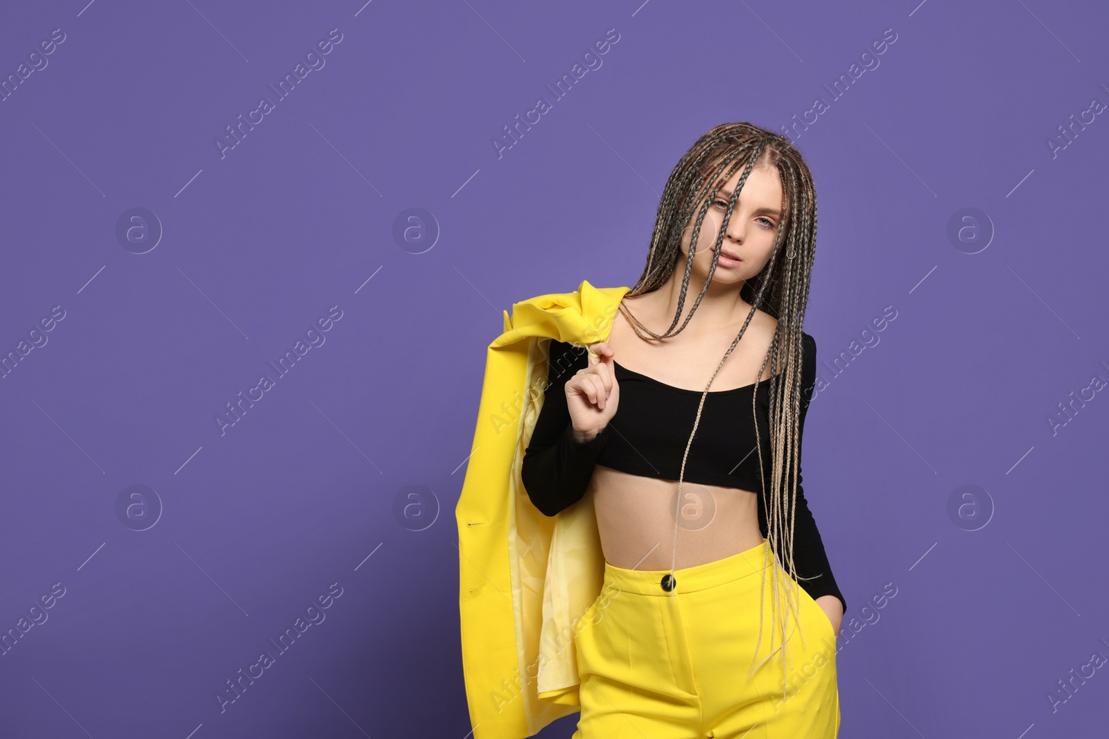 Photo of Beautiful woman with long african braids on purple background, space for text