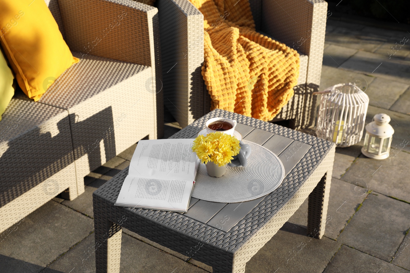 Photo of Beautiful rattan garden furniture, cup of tea and different decor elements outdoors