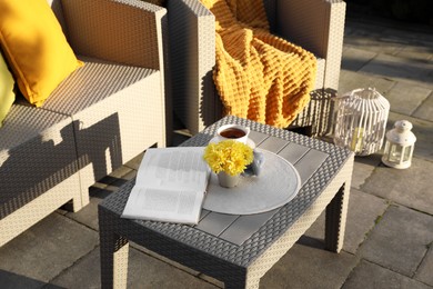 Photo of Beautiful rattan garden furniture, cup of tea and different decor elements outdoors