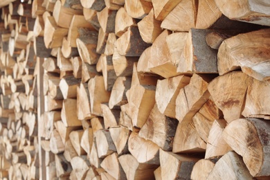 Photo of Stacked firewood as background, closeup. Heating house in winter