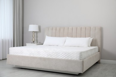 Photo of Comfortable bed with soft white mattress and pillows indoors