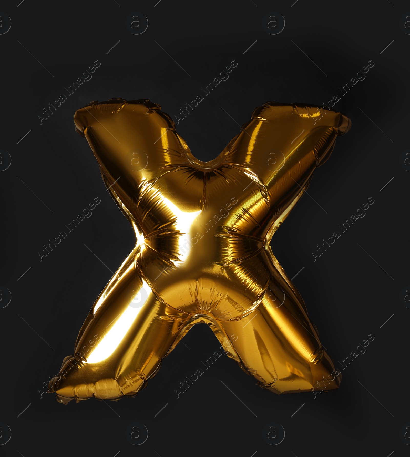 Photo of Golden letter X balloon on black background