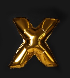 Photo of Golden letter X balloon on black background
