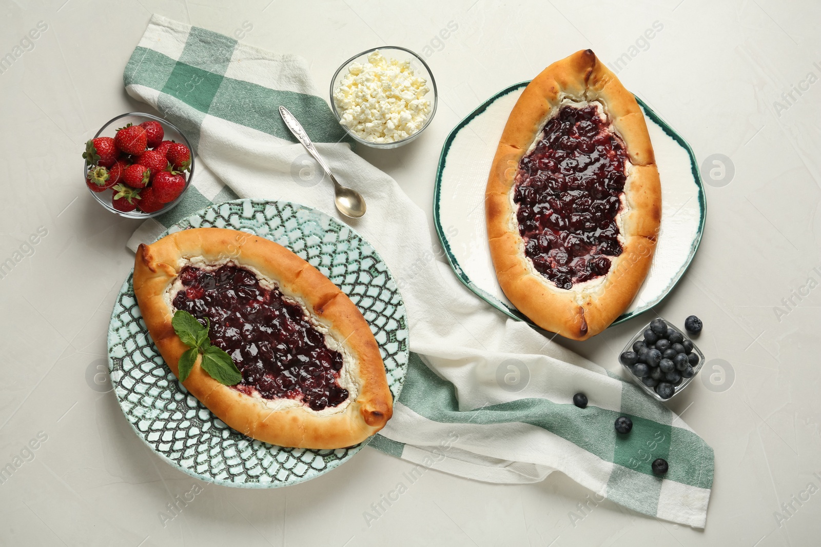 Photo of Delicious sweet cottage cheese pastry with cherry jam served on light table