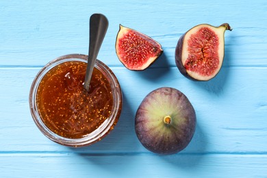 Jar of tasty sweet jam and fresh figs on light blue wooden table, flat lay