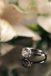 Beautiful engagement ring against blurred background, space for text