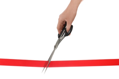 Photo of Woman cutting red ribbon with scissors on white background. Traditional ceremony