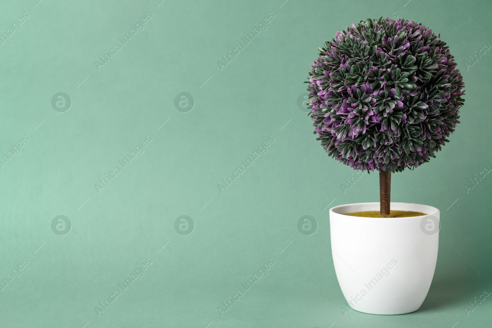 Photo of Beautiful artificial plant in flower pot on color background, space for text