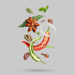 Image of Different spices falling on light grey background