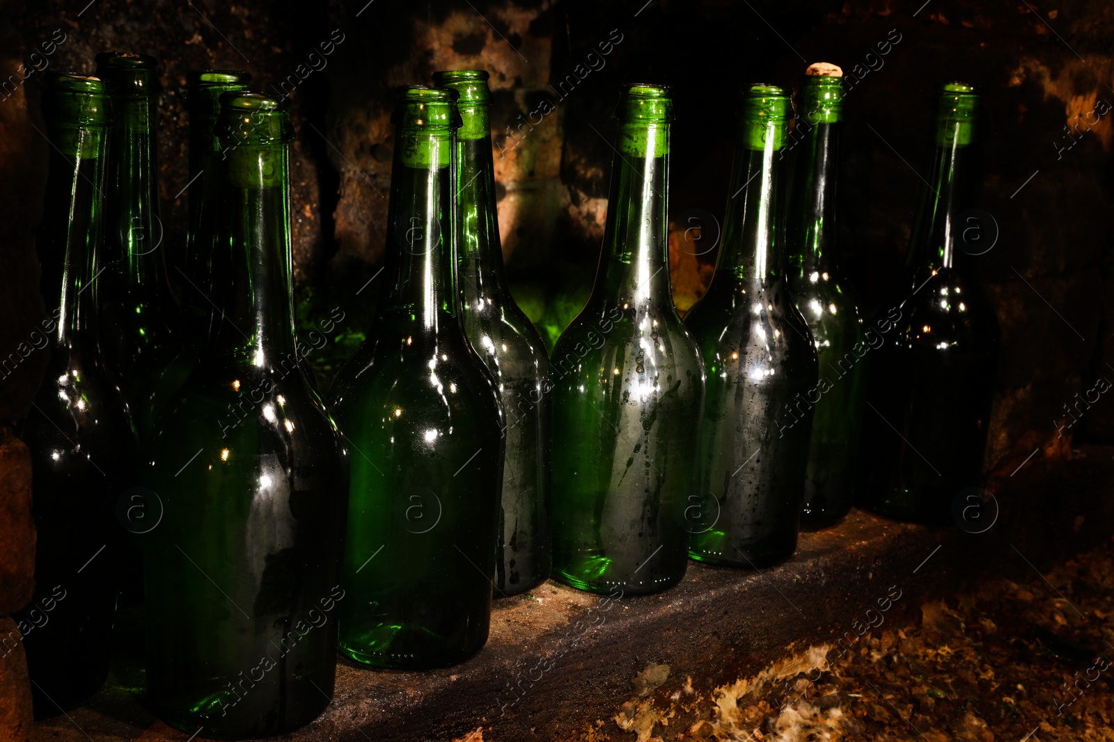 Photo of Many bottles of alcohol drinks on shelf in cellar